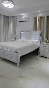 ein weißes Schlafzimmer mit einem großen Bett mit einem weißen Bettrahmen in der Unterkunft Rijos tower 3 in Santo Domingo