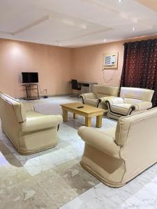 a living room with couches and a table and a television at Citilodge Hotel & Conference Centre in Abuja