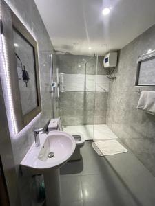 ein Bad mit einem Waschbecken, einem WC und einer Dusche in der Unterkunft Citilodge Hotel & Conference Centre in Abuja