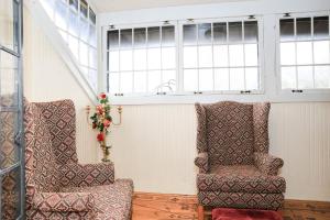 dwa krzesła siedzące w pokoju z oknami w obiekcie Stone Chalet Bed & Breakfast Inn w mieście Ann Arbor