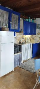 a kitchen with blue cabinets and a white refrigerator at Kynosoura's sea view in Ambelákia