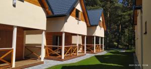 an external view of a house with a garage at BURSZTYNOWO Domy z saunami i jakuzzi in Ostrowo