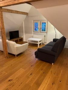 - un salon avec un canapé noir et une télévision dans l'établissement Loft Apartment in Central Zug, à Zoug