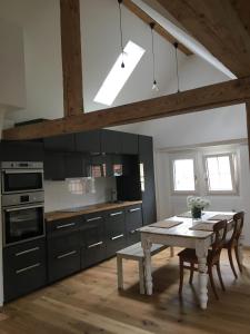 a kitchen with a white table and a table and chairs at Loft Apartment in Central Zug in Zug