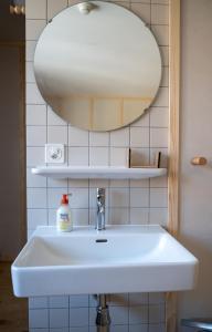 uma casa de banho com um lavatório branco e um espelho. em Hôtel-Restaurant du Cerf em Les Ponts-de-Martel