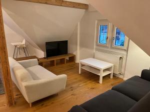 a living room with a couch and a tv at Loft Apartment in Central Zug in Zug