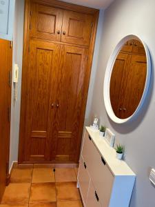 La salle de bains est pourvue d'une armoire en bois et d'un miroir. dans l'établissement Casa Lia, à Vejer de la Frontera