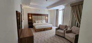 Habitación de hotel con cama y silla en فندق جولدن ايليت Golden Elite Hotel en Al Khobar