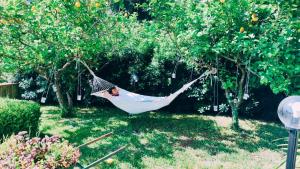 a woman sleeping in a hammock in a garden at Oasi love & relax in Maratea