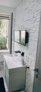 a white bathroom with a sink and a window at Oasi love & relax in Maratea