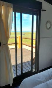 a bedroom with a window with a view of a deck at Posada Naranja in Mar del Plata
