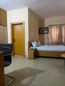 a hotel room with a bed and a door at Citilodge Hotel & Conference Centre in Abuja