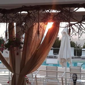 ein Sonnenschirm und Stühle neben einem Pool in der Unterkunft Villa Contessina in Cossignano