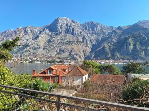 Vistas a una casa con montañas en el fondo en M&B apartment en Kotor