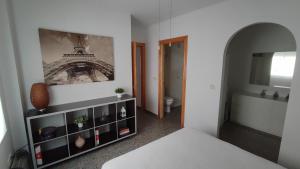 a room with a bed and a shelf with a picture on the wall at Apartamento VILLASOLETE in Fuengirola