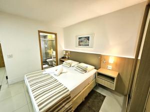 a hotel room with a bed and a mirror at Cullinan 1017E · Hotel Cullinan Luxury Premium com varanda in Brasilia