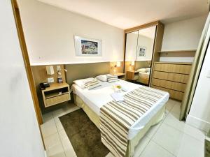 a small hotel room with a bed and a mirror at Cullinan 1017E · Hotel Cullinan Luxury Premium com varanda in Brasilia