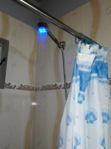 een douchegordijn met een blauw licht op een gordijnstang bij Mirna in Tranqueras