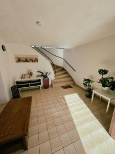 uma sala de estar com uma escada e vasos de plantas em Duplex avec jardin - Proche Paris - Disneyland - RER - em Noisy-le-Grand