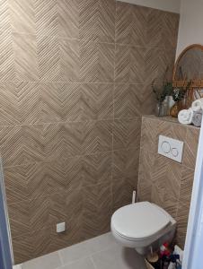 uma casa de banho com um WC e uma parede de azulejos em 2 chambres avec vue panoramique em Montauroux