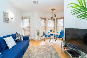 a living room with a blue couch and a table at Heart of London's West End / Pro Host in London