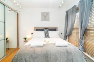 a bedroom with a large white bed with two pillows at Heart of London's West End / Pro Host in London