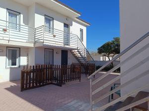 a white house with a wooden fence and stairs at Residence La Duna in Castel Volturno
