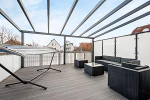 a large roof deck with a couch and chairs at I Zentral I Modern I Terrasse I in Rüsselsheim