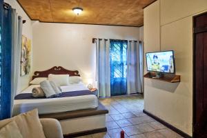 a bedroom with a bed and a tv in it at Casas Mal Pais in Mal País