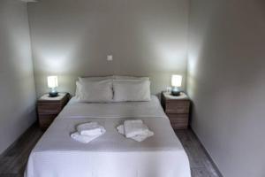 sypialnia z łóżkiem z dwoma ręcznikami w obiekcie EORA LUXURY APARTMENT, Kamari Xylokastro w mieście Kamárion