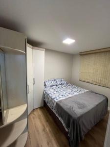 1 dormitorio con cama y ventana. en Apartamento Condomínio Fechado, en São José dos Pinhais