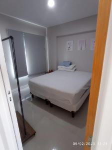 1 dormitorio con 1 cama blanca en una habitación en DEPARTAMENTO PUERTO MADRYN en Puerto Madryn