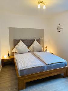 a bedroom with a large bed with a wooden headboard at Ferienwohnung Ambiente in Klotten