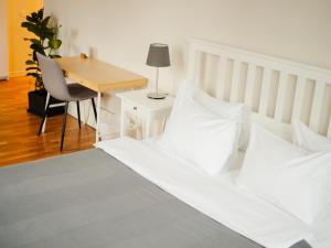 Danylo Inn في إلفيف: غرفة نوم مع سرير مع وسائد بيضاء ومكتب