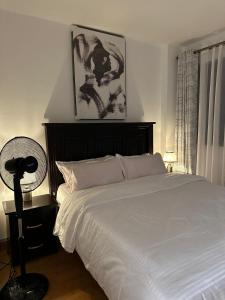 a bedroom with a white bed and a fan at Outer homes in Nairobi