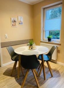 uma sala de jantar com uma mesa branca e cadeiras em Ferienwohnung Ambiente em Klotten