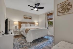 1 dormitorio blanco con 1 cama y ventilador de techo en Beachy 3BD Bungalow One Block from Scenic Walkway, en Oak Island