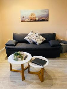 ein Wohnzimmer mit einem Sofa und einem Tisch mit einem Laptop in der Unterkunft Ferienwohnung Ambiente in Klotten