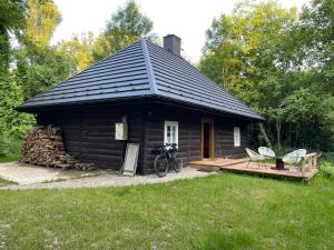 ein Blockhaus mit einer Veranda und einem Fahrrad auf einem Deck in der Unterkunft A to Cichata - Agroturystyka in Odrzykoń
