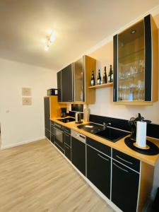 uma cozinha com armários pretos e um lavatório em Ferienwohnung Ambiente em Klotten