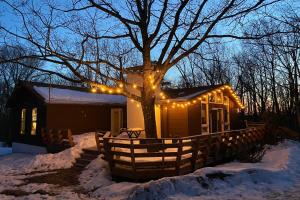 a house with christmas lights on it in the snow at Chestnut Tree Lodge - Modern Wooded Escape in Jim Thorpe