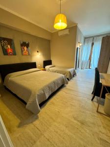 sypialnia z 2 łóżkami, stołem i lampką w obiekcie Doina Guest House w Rzymie