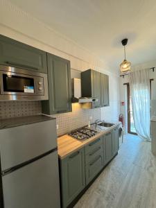 a kitchen with green cabinets and a stove top oven at Doina Guest House in Rome