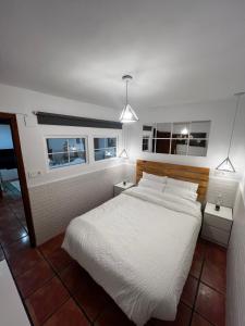 um quarto com uma cama branca e duas mesas de cabeceira em Cozy Apartment In Rural Village em Barruelo de Santullán