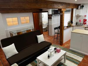 uma sala de estar com um sofá e uma cozinha em Cozy Apartment In Rural Village em Barruelo de Santullán