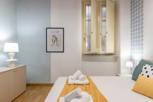 una camera da letto bianca con due asciugamani su un letto di Corte D'Appello Houses a Torino