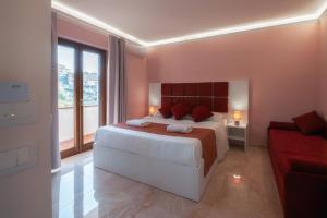 - une chambre avec un grand lit et un canapé rouge dans l'établissement La Perla Nascosta, à Belvedere Marittimo