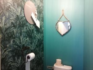 La salle de bains est pourvue d'un miroir et de toilettes. dans l'établissement La maison O kiwis - Chambres d'hôtes, à Saint-Denis-lès-Martel