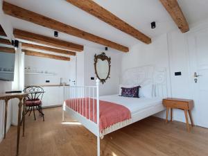 a bedroom with a white bed and a table at M&R Apartments II in Koper