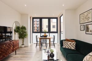 a living room with a green couch and a table at The Harlesden Hideout - Charming 2BDR Flat in London